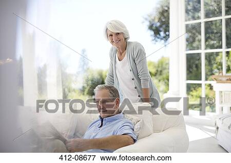 Stock Photo - Senior couple relaxing on patio sofa. Fotosearch
