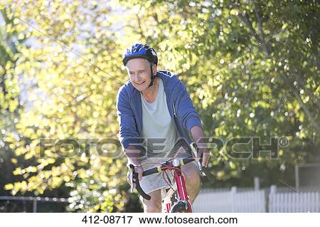 Senior man riding bicycle in park View Large Photo Image Stock Photo - Senior man riding bicycle in park. Fotosearch