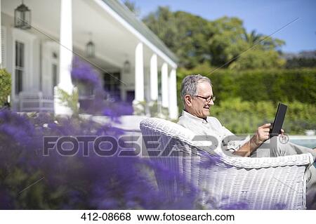 Senior man using digital tablet in garden View Large Photo Image Stock Photo - Senior man using digital tablet in garden. Fotosearch