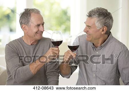 Stock Image - Senior men toasting wine glasses. Fotosearch