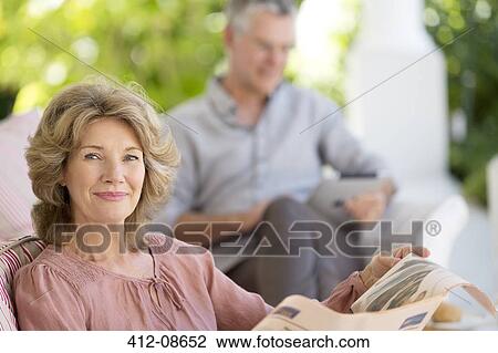 Senior woman reading newspaper on patio View Large Photo Image Stock Image - Senior woman reading newspaper on patio. Fotosearch