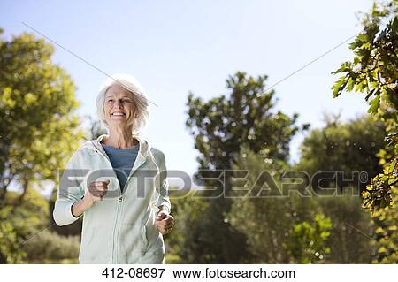 Senior woman running in park View Large Photo Image Stock Photo - Senior woman running in park. Fotosearch