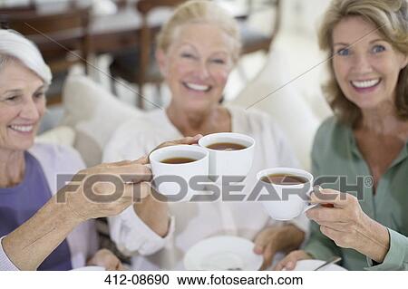 Senior women toasting coffee cups View Large Photo Image Stock Image - Senior women toasting coffee cups. Fotosearch