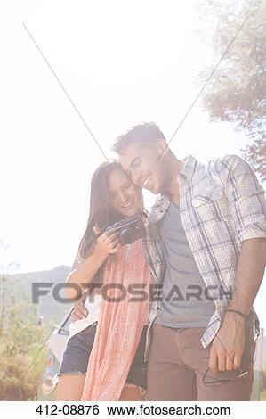 Stock Photograph - Couple looking at digital camera outdoors. Fotosearch
