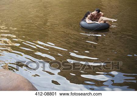 Couple playing in inner tube in lake View Large Photo Image Stock Image - Couple playing in inner tube in lake. Fotosearch