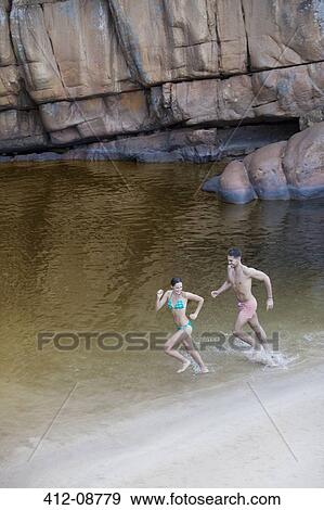 Couple running in lake View Large Photo Image Stock Photo - Couple running in lake. Fotosearch