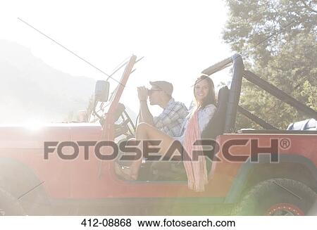 Stock Photo - Couple sitting in sport utility vehicle. Fotosearch