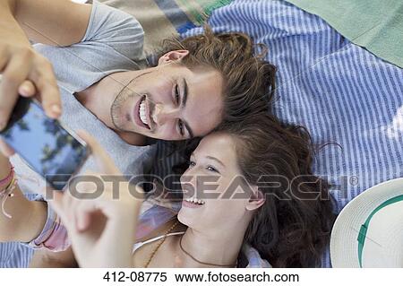 Stock Photography - Couple taking self-portrait with camera phone. Fotosearch