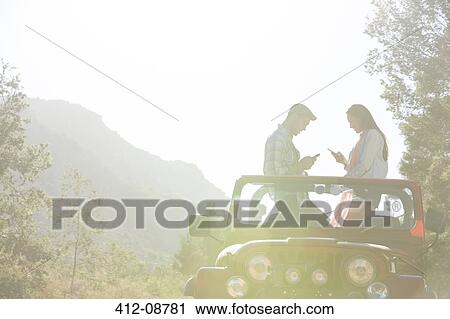 Couple using cell phones in sport utility vehicle View Large Photo Image Stock Image - Couple using cell phones in sport utility vehicle. Fotosearch