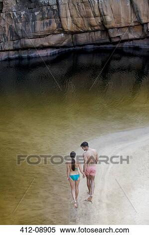 Couple walking along pool View Large Photo Image Stock Photography - Couple walking along pool. Fotosearch