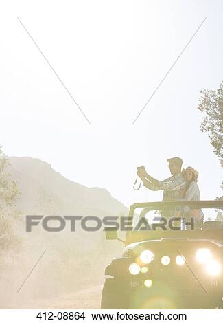 Couple with digital camera in sport utility vehicle View Large Photo Image Picture - Couple with digital camera in sport utility vehicle. Fotosearch