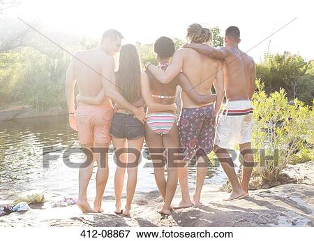 Stock Photo - Friends hugging at riverside. Fotosearch