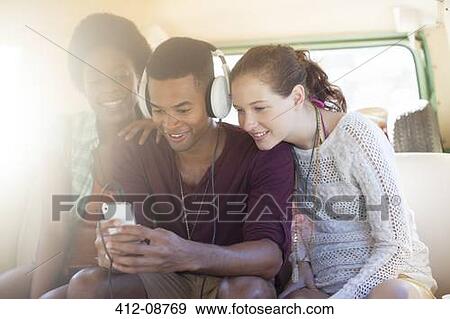 Friends listening to mp3 player in camper van View Large Photo Image Stock Photo - Friends listening to mp3 player in camper van. Fotosearch