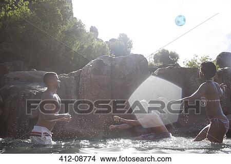 Picture - Friends playing soccer in river. Fotosearch