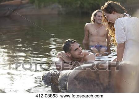 Stock Image - Friends relaxing in lake. Fotosearch