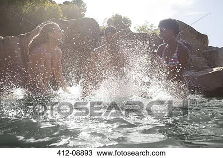 Stock Image - Friends splashing in river. Fotosearch