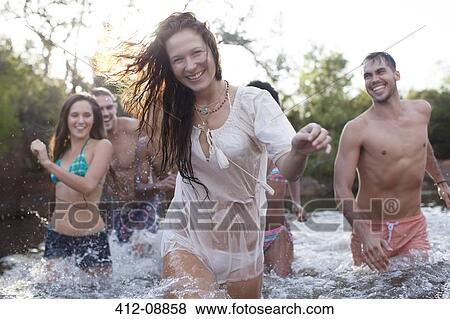 Stock Photo - Friends wading in river. Fotosearch