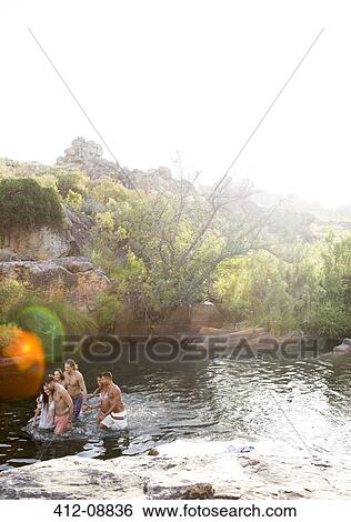 Stock Photograph - Friends wading in river. Fotosearch