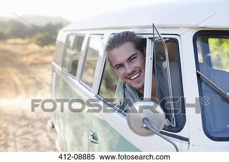 Stock Photography - Man driving camper van on dirt road. Fotosearch