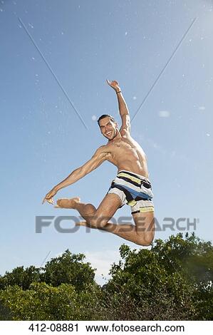 Man in swim trunks jumping View Large Photo Image Stock Image - Man in swim trunks jumping. Fotosearch