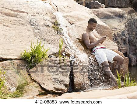 Man using cell phone by waterfall View Large Photo Image Stock Image - Man using cell phone by waterfall. Fotosearch