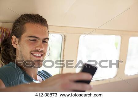 Man using cell phone in camper van View Large Photo Image Stock Image - Man using cell phone in camper van. Fotosearch