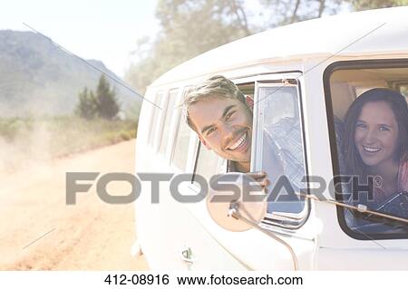 Stock Photograph - Portrait of smiling couple in camper van. Fotosearch