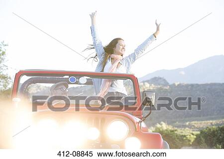 Stock Photography - Woman cheering in sport utility vehicle. Fotosearch