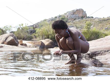 Stock Photography - Woman cupping water in river. Fotosearch