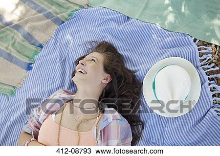 Woman laying on blanket outdoors View Large Photo Image Stock Image - Woman laying on blanket outdoors. Fotosearch