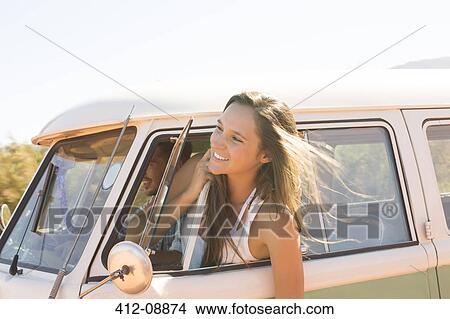 Picture - Woman leaning head out camper van window. Fotosearch