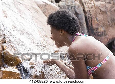 Stock Photography - Woman playing in waterfall. Fotosearch