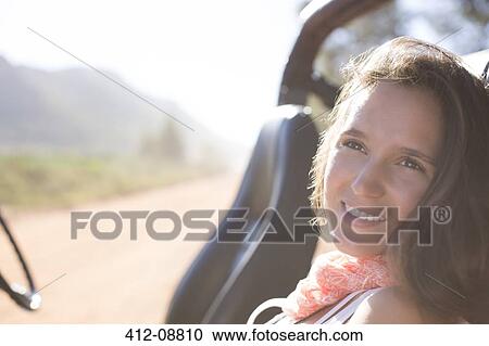 Stock Image - Woman relaxing in sport utility vehicle. Fotosearch