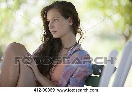 Stock Photo - Woman sitting on park bench. Fotosearch