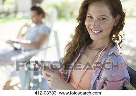 Woman using cell phone on bench View Large Photo Image Stock Image - Woman using cell phone on bench. Fotosearch