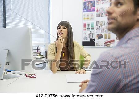 Stock Photograph - Business people at desk in office. Fotosearch