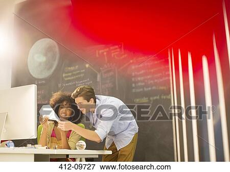 Stock Photo - Business people examining model in office. Fotosearch