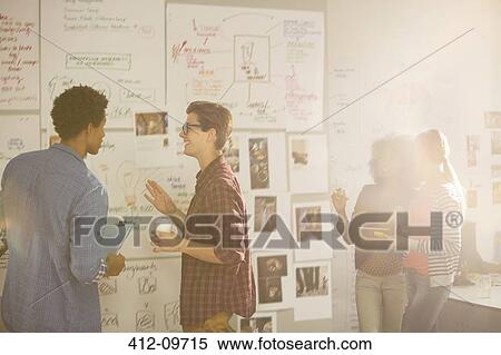 Stock Photography - Business people looking at flow charts in meeting. Fotosearch