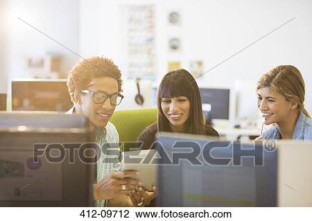 Stock Image - Business people using digital tablet in office. Fotosearch