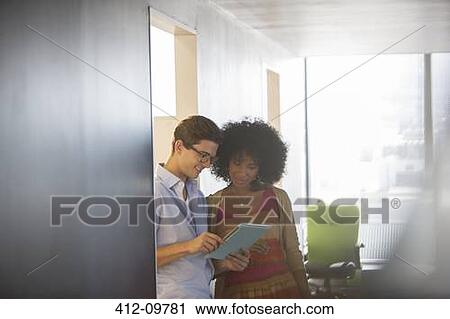 Stock Image - Business people using digital tablet in office. Fotosearch