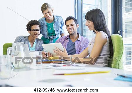 Stock Photograph - Business people using digital tablet in meeting. Fotosearch