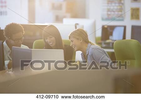 Stock Image - Business people using laptop in office. Fotosearch