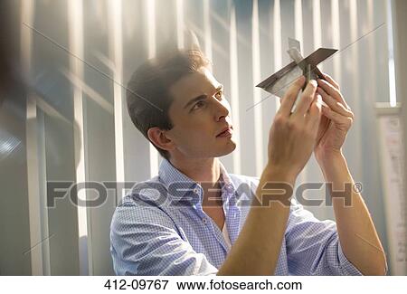 Businessman examining model in office View Large Photo Image Stock Photo - Businessman examining model in office. Fotosearch