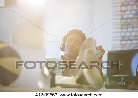 Businessman relaxing at desk in office View Large Photo Image Stock Photo - Businessman relaxing at desk in office. Fotosearch