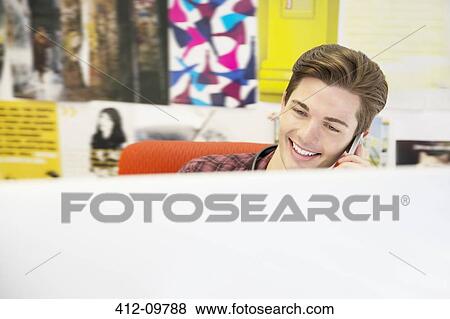 Businessman talking on cell phone in office View Large Photo Image Stock Photo - Businessman talking on cell phone in office. Fotosearch