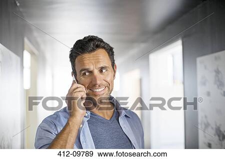 Businessman talking on cell phone in corridor View Large Photo Image Stock Photo - Businessman talking on cell phone in corridor. Fotosearch