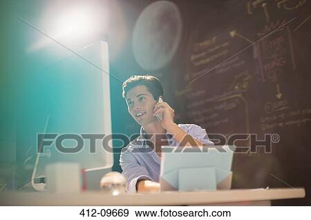 Businessman talking on telephone in office View Large Photo Image Stock Photo - Businessman talking on telephone in office. Fotosearch