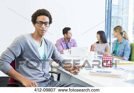 Businessman using cell phone in meeting View Large Photo Image Stock Photo - Businessman using cell phone in meeting. Fotosearch