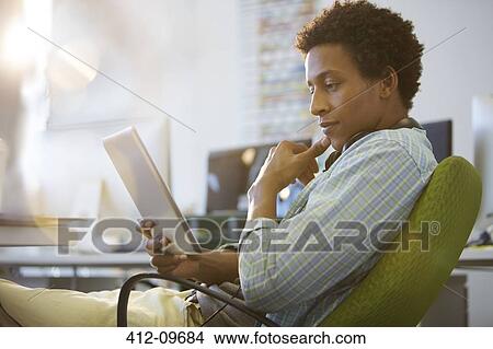 Picture - Businessman using digital tablet in office. Fotosearch