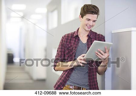 Stock Photo - Businessman using digital tablet in office. Fotosearch